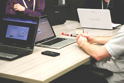 Office meeting around table with computers